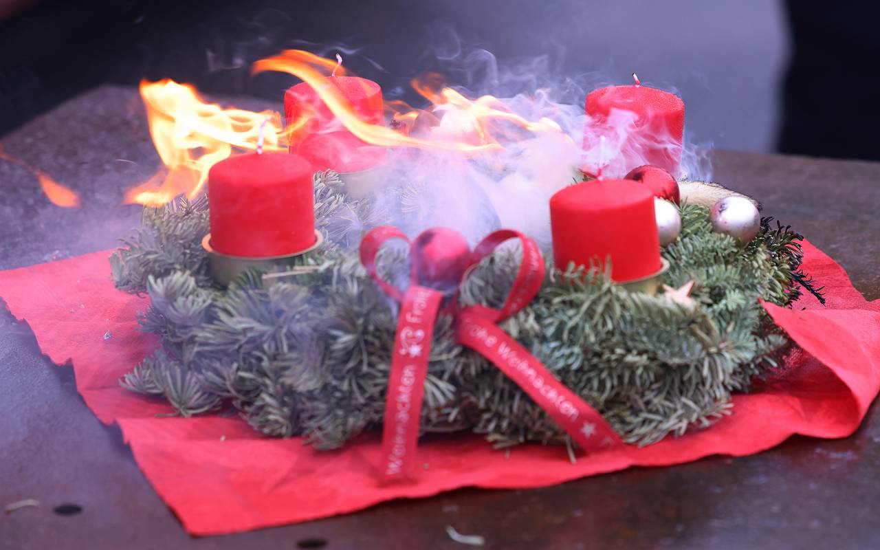Feuer gefangen: Ein Adventskranz mit roten Kerzen und Deko in Flammen.