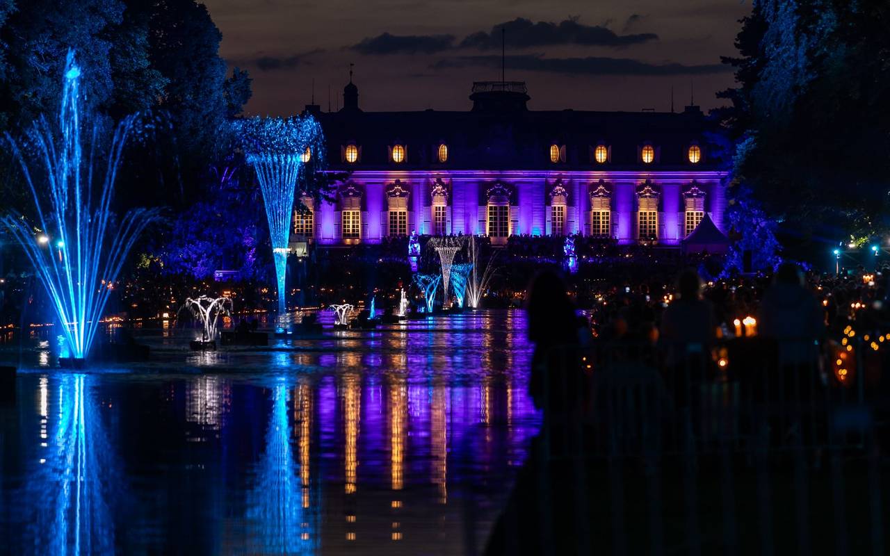 Der Spiegelweiher leuchetet beim Benrather Lichterfest in blau und lila.