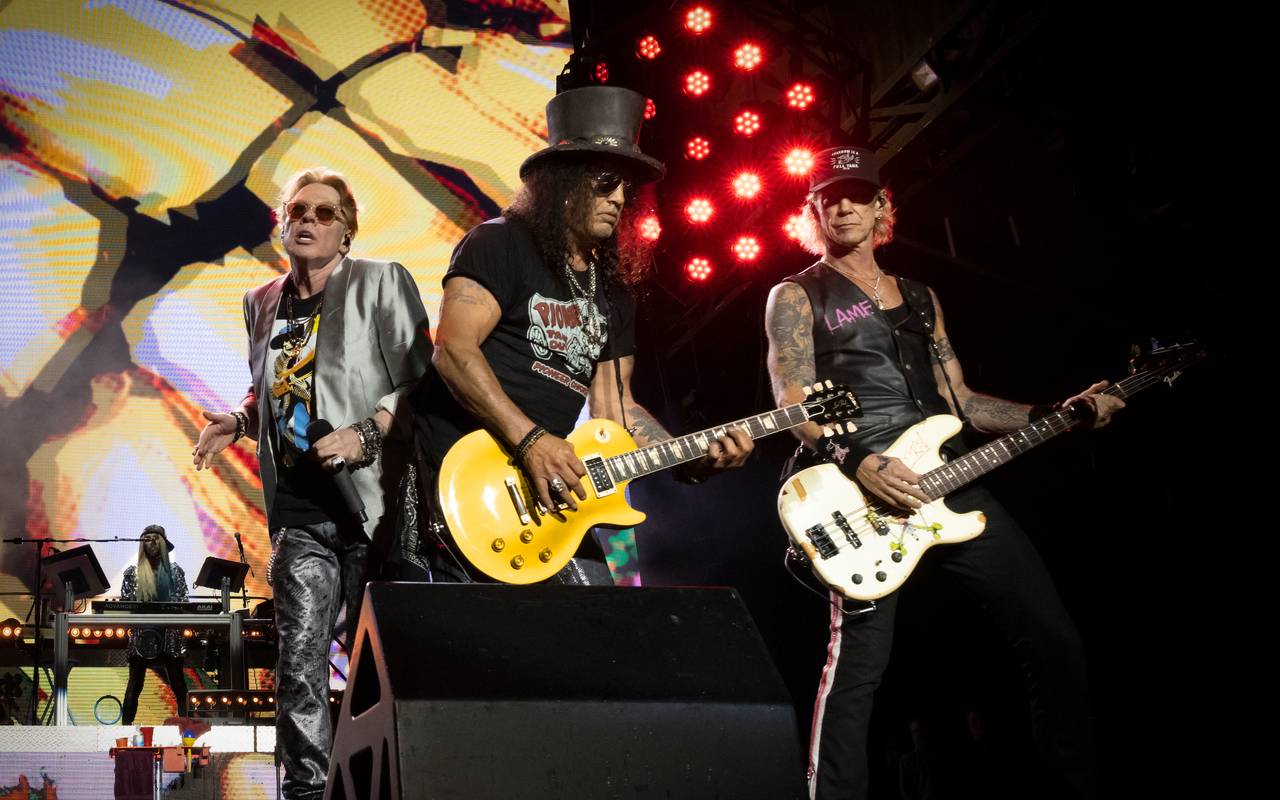 Die Band GUNS N’ ROSES auf einer Bühne. Im Mittelpunkt steht Gittarist Slash.