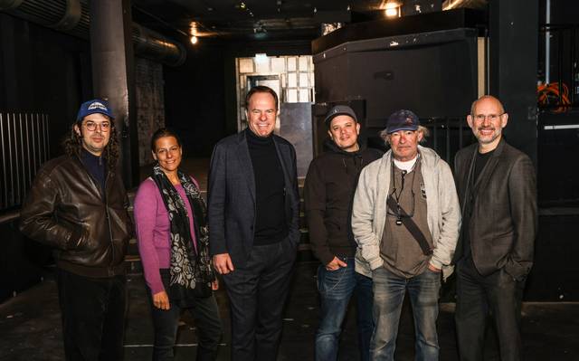 OB Keller und die neue Crew für den Ratinger Hof in der abgedunkelten Location. Von links nach rechts stehen nebeneinander: Felix Wursthorn, Music Düsseldorf; Daniela Stork, D.LIVE; OB Keller; Nico Hamm, concert team nrw; Berni Lewkowicz, concert team nrw und Michael Brill, CEO D.LIVE.