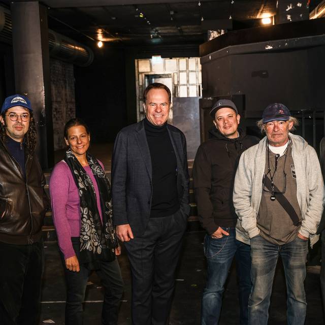 OB Keller und die neue Crew für den Ratinger Hof in der abgedunkelten Location. Von links nach rechts stehen nebeneinander: Felix Wursthorn, Music Düsseldorf; Daniela Stork, D.LIVE; OB Keller; Nico Hamm, concert team nrw; Berni Lewkowicz, concert team nrw und Michael Brill, CEO D.LIVE.