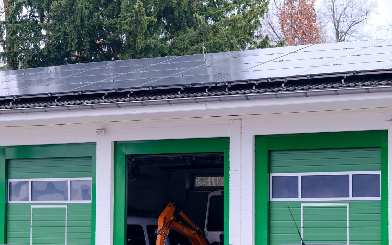 Eine neue Photovoltaikanlage befindet sich auf dem Dach des Betriebshofes am Friedhof Stoffeln. Das Haus ist in weiß und vor allem grün gehalten. Im Hintergrund sind Bäume zu sehen.