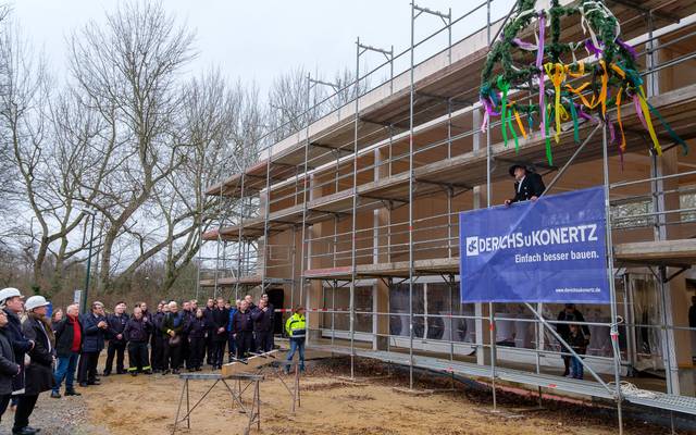 An der Baustelle der neuen Feuerwache in Kaiserswerth wird Richtfest gefeiert. Ein Bauarbeiter spricht zu den anwesenden Gästen.