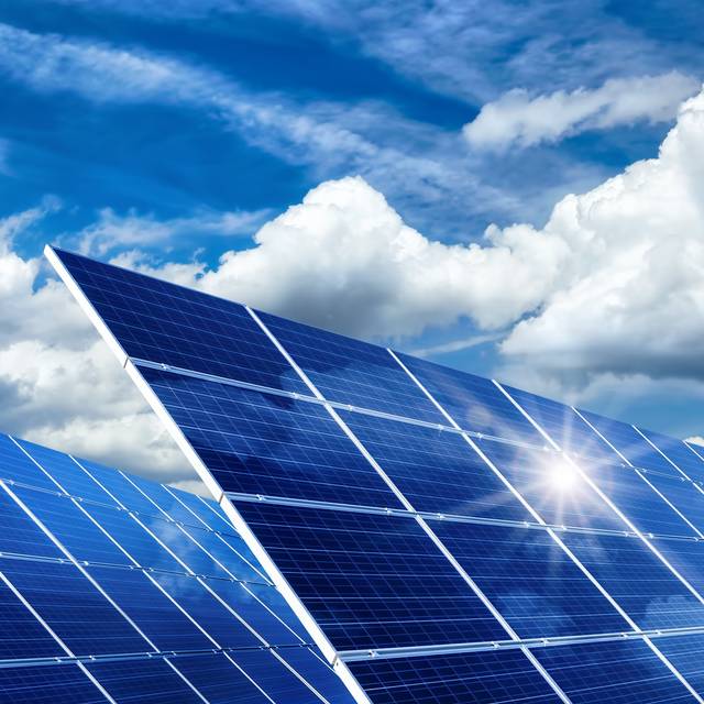 Solarkollektoren, Sonne und Wolken. Der Himmel ist blau.