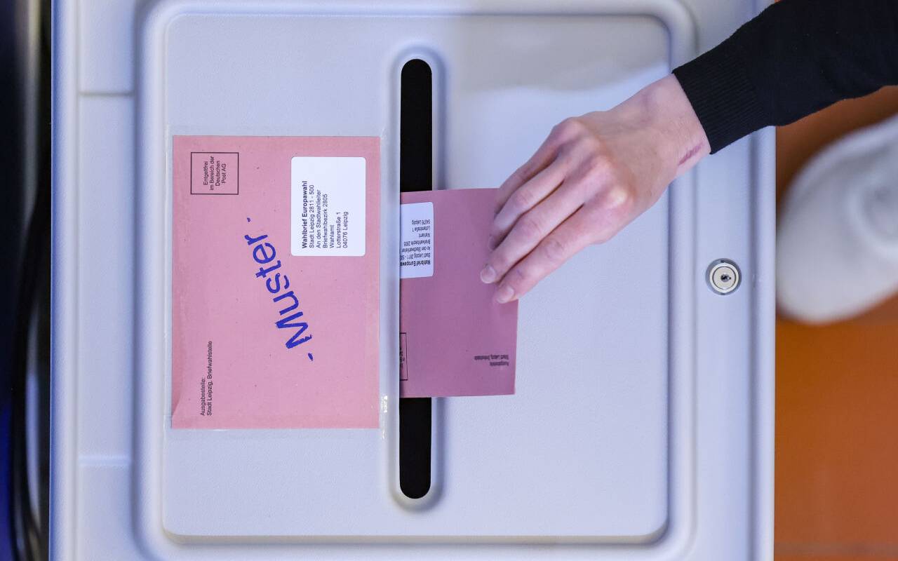 Eine Frau wirft den Umschlag mit dem Stimmzettel für die Europawahl in eine Wahlurne in der eröffneten Briefwahlstelle im Neuen Rathaus der Stadt Leipzig.