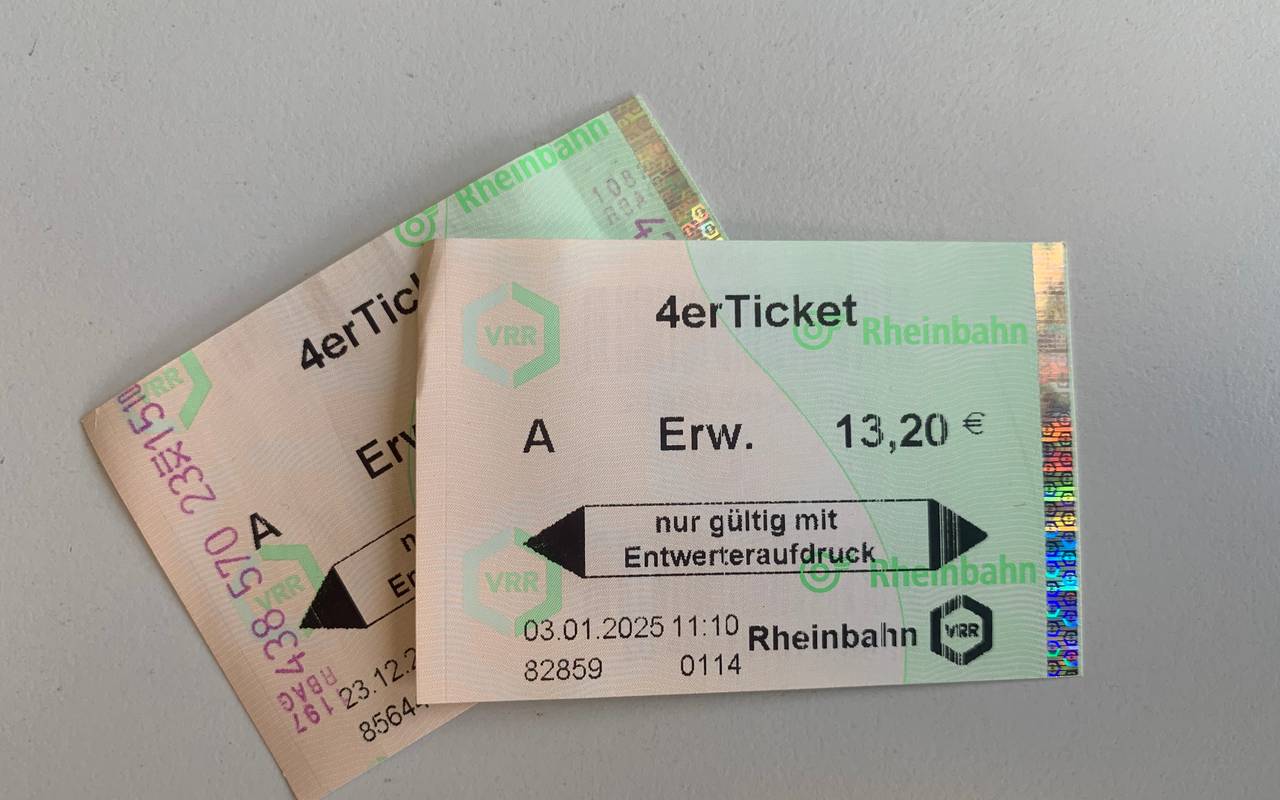 Zwei Papiertickets der Rheinbahn liegen auf einem weißen Tisch.