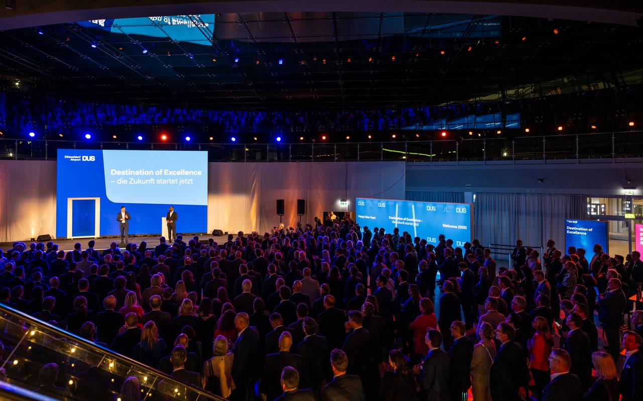 Rund 800 Gäste beim Neujahrsempfang des Flughafen Düsseldorf 2025. Auf der Bühne stehen die Geschäftsführer des Flughafens und halten einen Vortrag