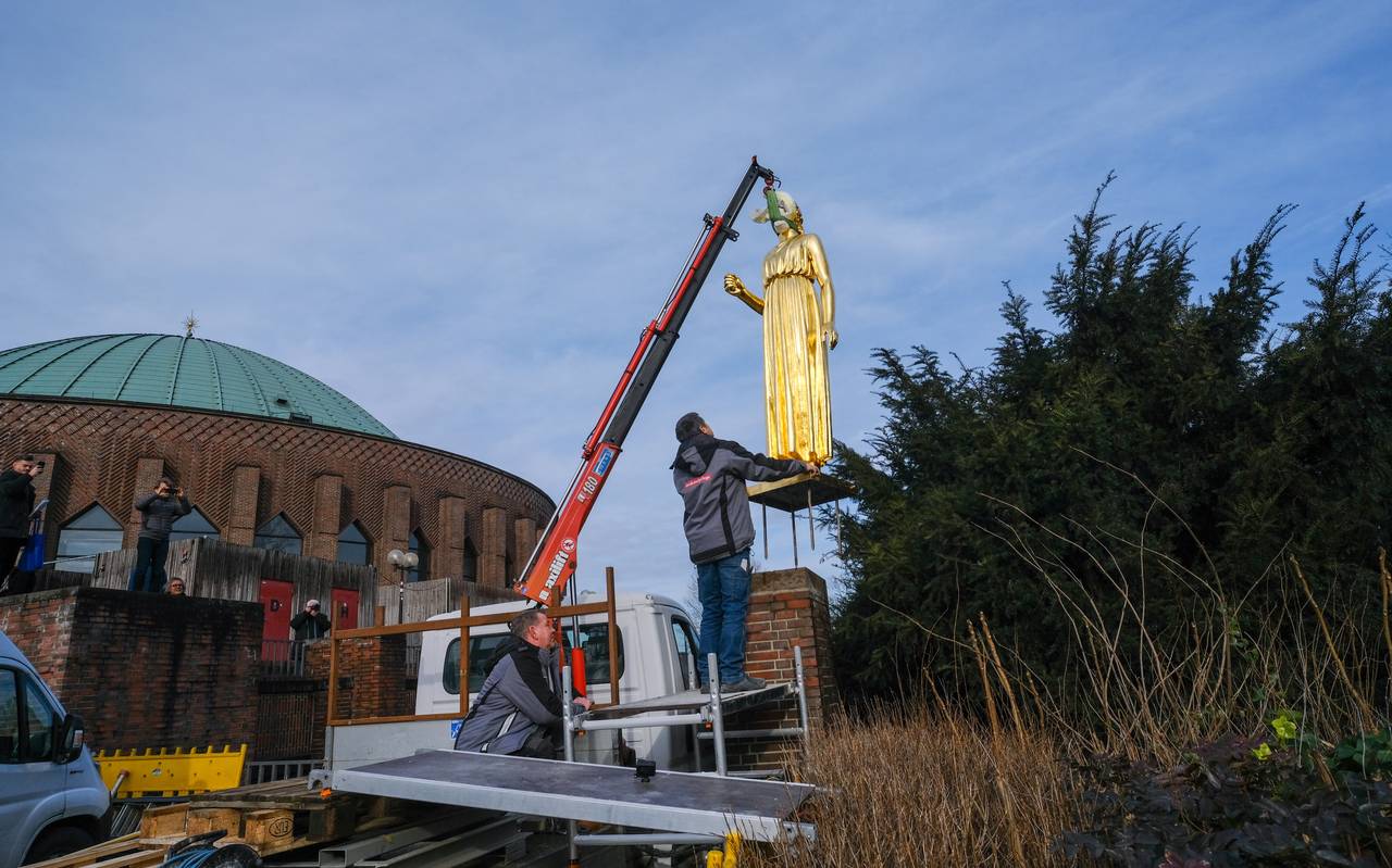 Die sanierte, goldene Statue "Pallas Athene" wird mit einem Kran wieder in der Nähe der Tonhalle aufgestellt. Die Figur hängt hier noch in der Luft.