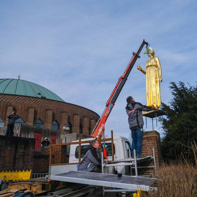 Die sanierte, goldene Statue "Pallas Athene" wird mit einem Kran wieder in der Nähe der Tonhalle aufgestellt. Die Figur hängt hier noch in der Luft.