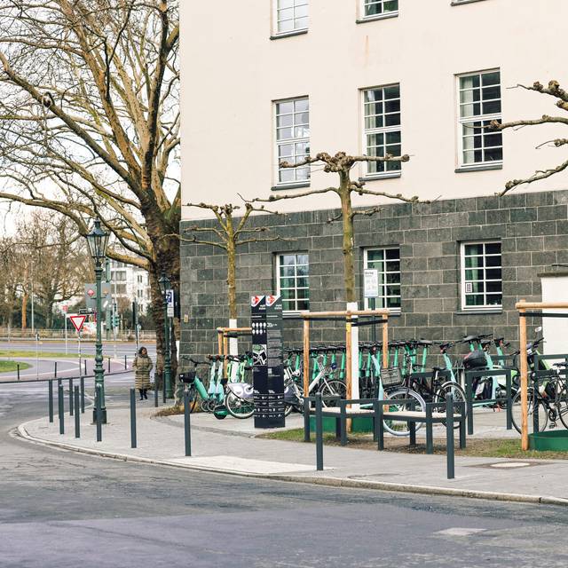 Die neu errichtete Mobilitätsstation direkt gegenüber dem Eingang der Kunstakademie mit Bäumen und Sitzgelegenheiten.