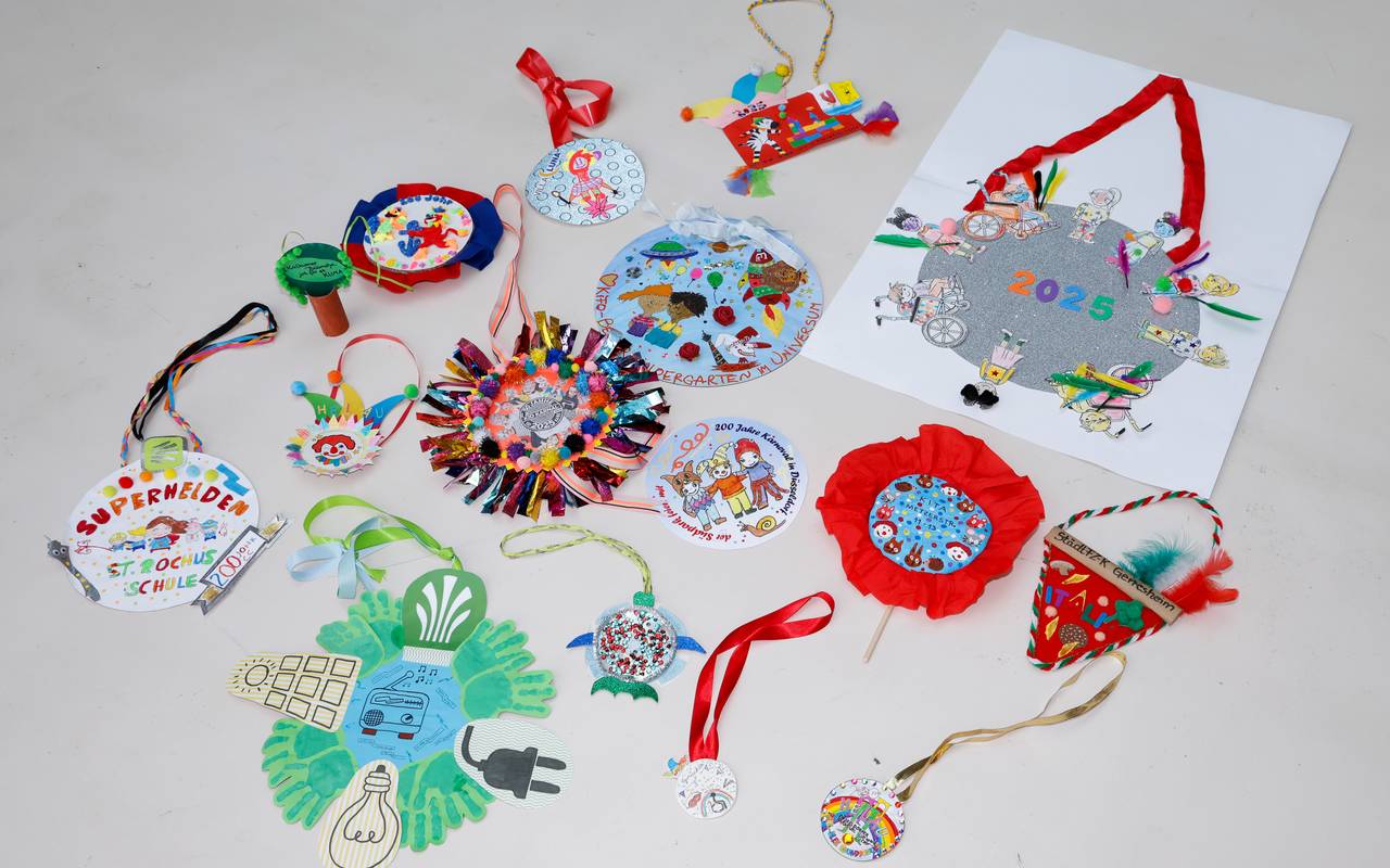 Viele bunt-gestaltete Orden aus Papier und Pappe, erstellt von diversen Kita-Gruppen und Schulklassen