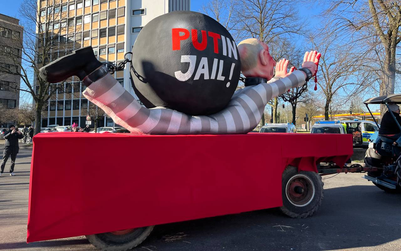 Mottowagen beim Karneval:  Putin als Häftling angezogen liegt am Boden, auf ihm eine Sträflingskugel.