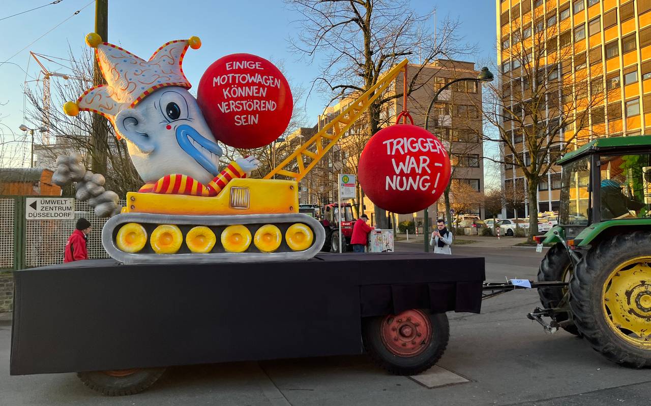 Mottowagen beim Karneval:  Der Karneval als Abrissbirne im Clownskostüm, die Kugel als Triggerwarnung.