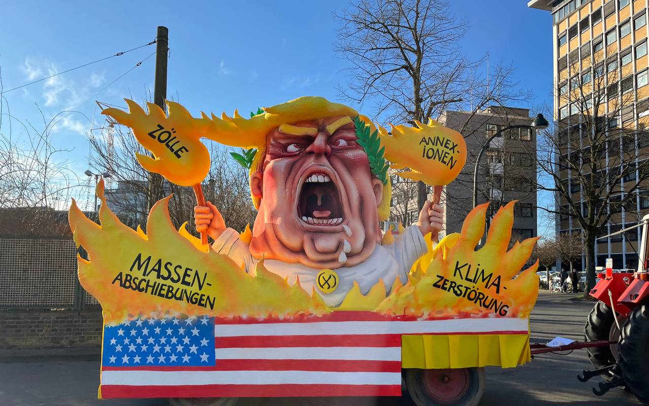 Mottowagen beim Karneval:  Trump schreiend zwischen Flammen und hält selbst die Fackeln in der Hand