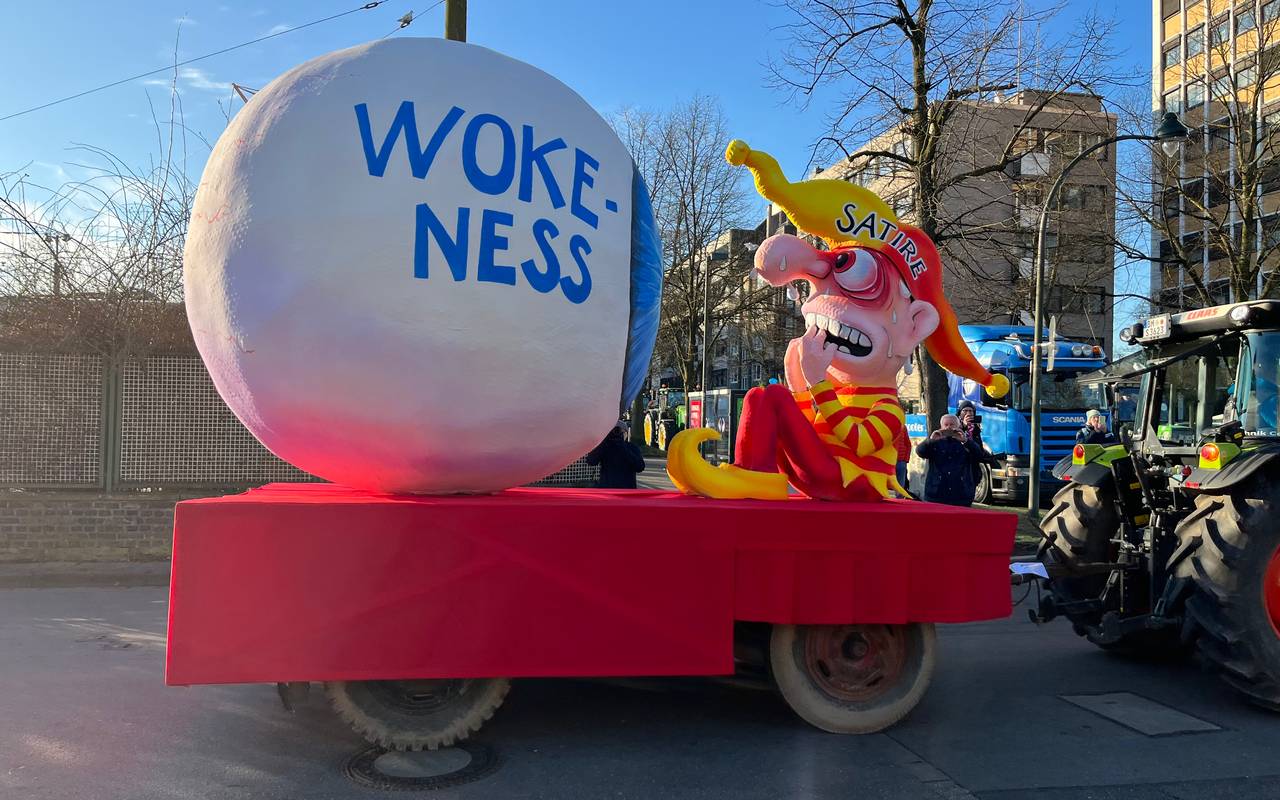 Mottowagen beim Karneval: Ein riesiges Auge, auf dem Wokeness steht, schaut auf die zitternde Satire