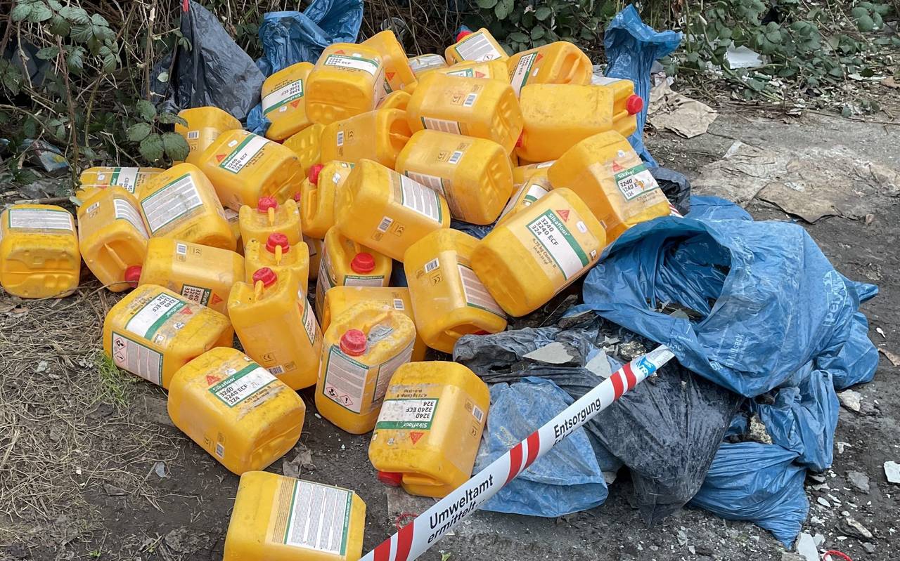 Viele gelbe Kanister liegen weggeworfen auf einer Straße in Oberbilk. Daneben liegen vor einer Hecke mehrere blaue Müllsäcke.