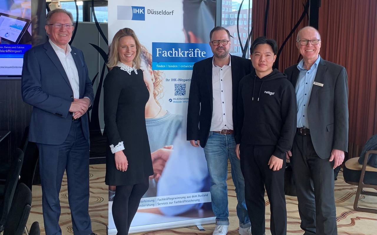 Zu sehen sind Vertreterinnen und Vertreter der IHK Düsseldorf, Hyatt Regency Hotel und Netigo GmbH. Sie stehen vor einem Schild zum Thema "Fachkräfte".