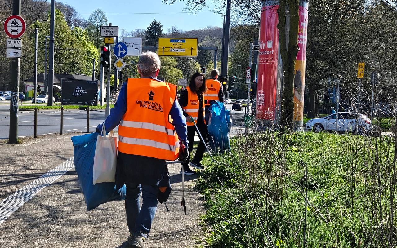 Freiwillige mit "gibt dem Müll eine Abfuhr" Warnweste