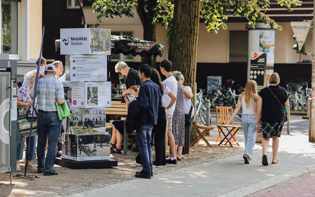 Eine Mobilitätsstation in Düsseldorf mit Menschen davor