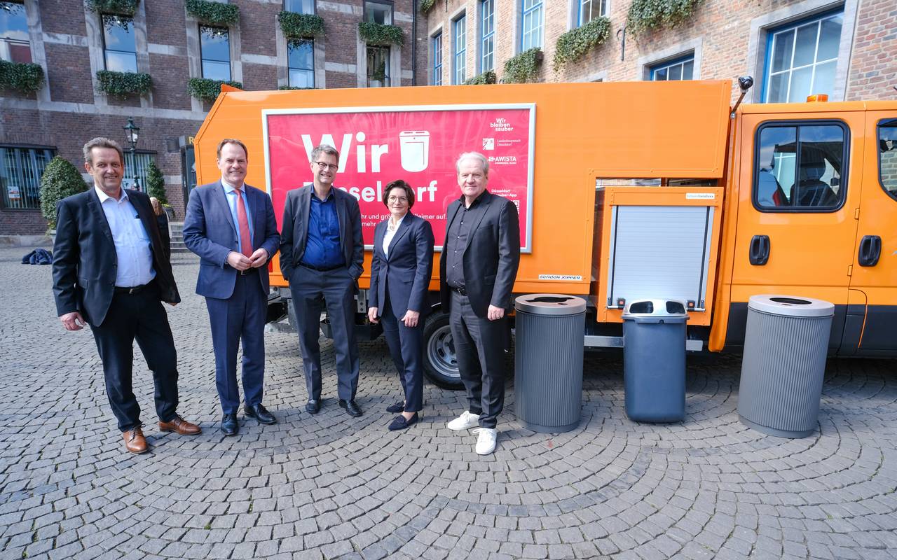 OB Keller und Mitarbeitende von Stadt und AWISTA präsentieren die aktuelle Sauberkeitsoffensive. Sie stehen neben verschiedenen Mülltonnen vor einem AWISTA-Fahrzeug. Dieses ist auf dem Marktplatz vor dem Rathaus in der Altstadt abgestellt.