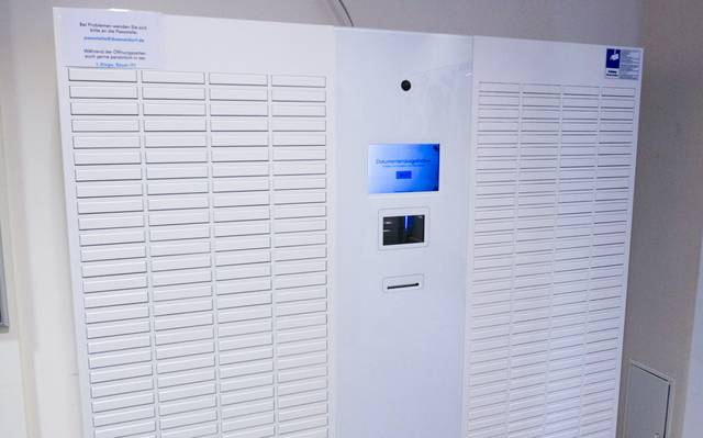 Weiße Ausgabebox für Dokumente, in der Mitte ein kleiner Bildschirm