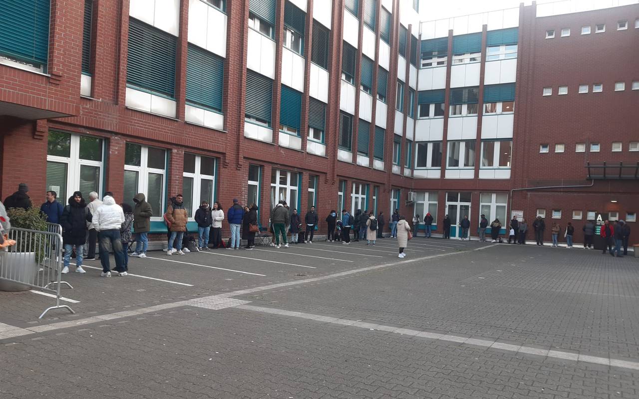 Menschen warten vor der Ausländerbehörde auf der Erkrather Straße.