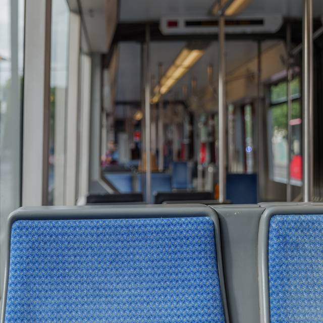 Innenansicht einer Straßenbahn der Rheinbahn. Die Sitze sind leer und blau.