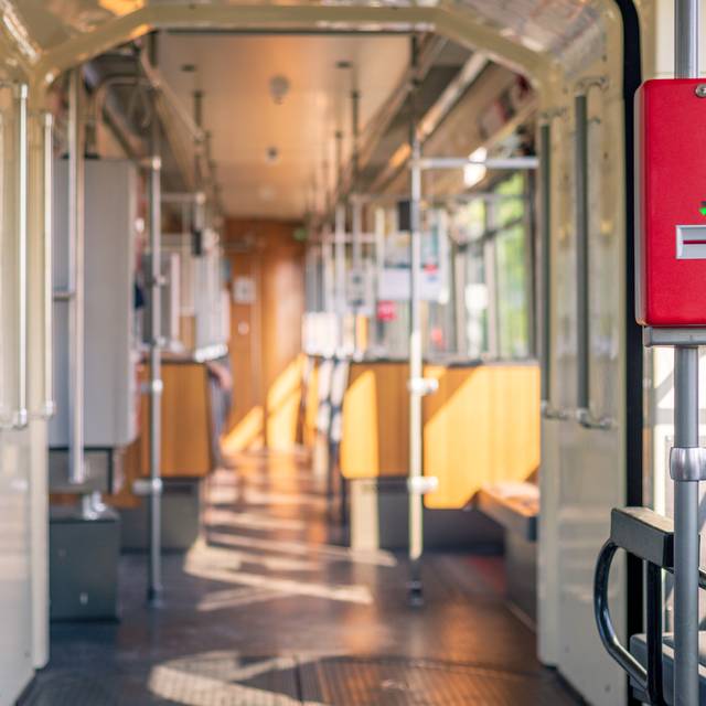 Innenansicht einer U-Bahn der Rheinbahn. Die U-Bahn ist sonnendurchflutet. Die Sitze der Bahn sind leer.