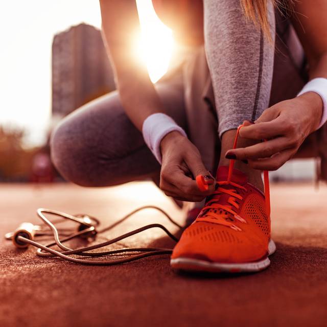 Eine Frau bereitet sich auf einen Lauf vor. Sie wird gleich joggen gehen.
