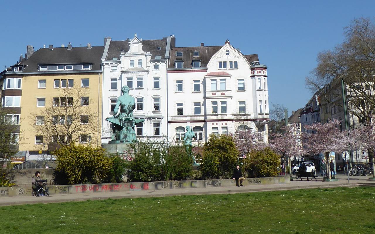Der Fürstenplatz. Im Vordergrund Rasen, im Hintergrund schöne alte Häuser, dazwischen ein Brunnen.