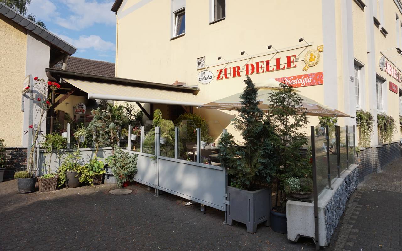 Restaurant Nostalgia Zur Delle mit Terrasse und Gebäude.