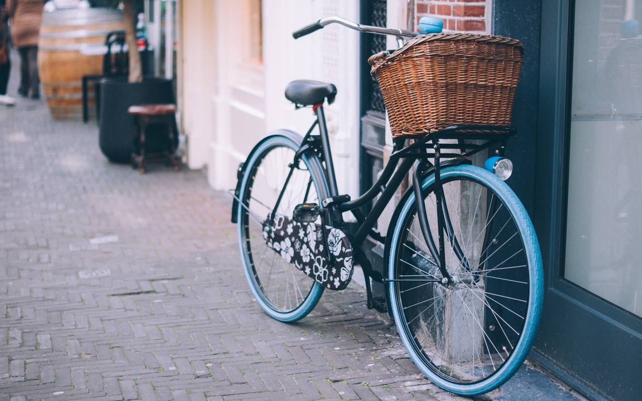 Ein Fahrrad mit blauen Reifen und einem braunen Körbchen.