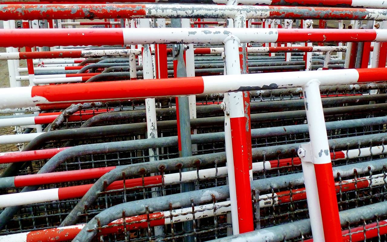 Gestapelte rot-weiße Absperrgitter.