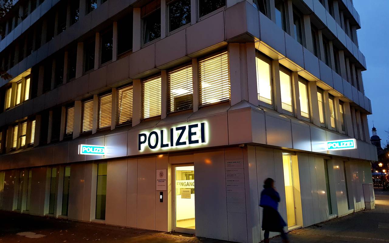 Außenansicht der beleuchteten Polizeiwache in der Düsseldorfer Altstadt bei Dunkelheit.