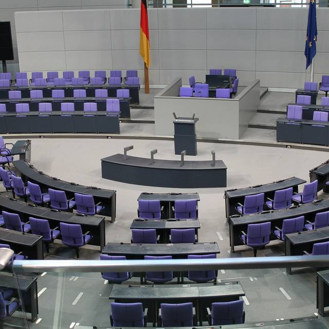 Der Bundestag in Berlin. Fotografiert von der Empore im Zuschauerraum. Die Stühle und auch die Regierungsbank sind leer.