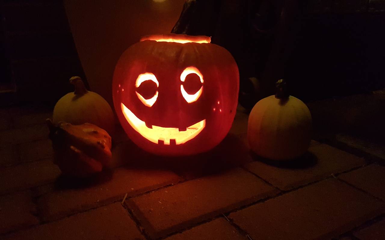 Ein geschnitzter Halloween-Kürbis. Eine Kerze im Inneren beleuchtet den Kürbis mit seiner Grimasse.
