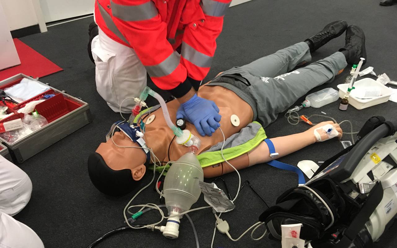 Ein Sanitäter zeigt an einer Puppe, wie man richtig reanimiert.
