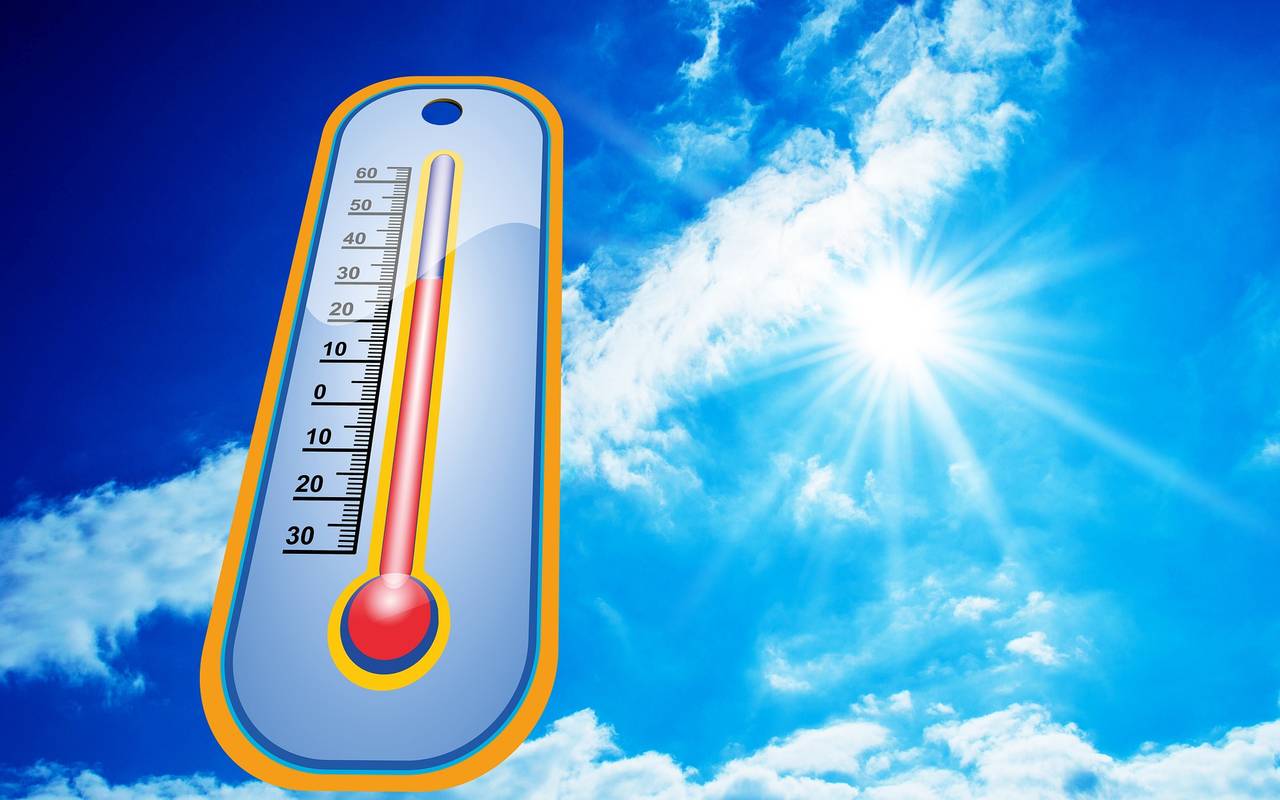 Ein Thermometerzeigt hohe Temperaturen an. Die Sonne brennt von einem blauen Himmel.