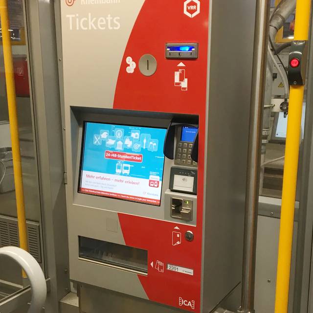 Ein rot-grauer Ticketautomat der Rheinbahn in einer Straßenbahn.