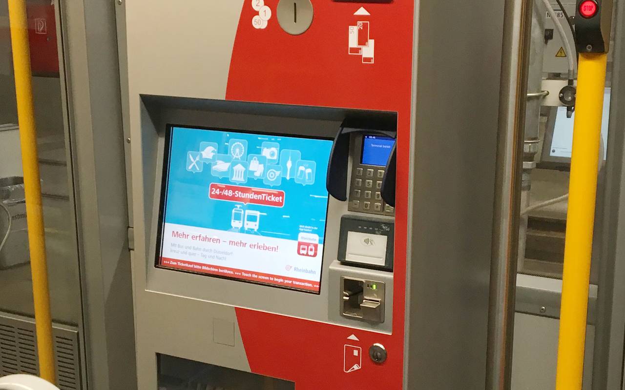 Ein rot-grauer Ticketautomat der Rheinbahn in einer Straßenbahn.