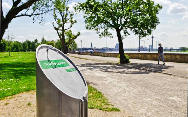 Ein Trinkwasserbrunnen von den Stadtwerken Düsseldorf im Rheinpark in Golzheim. Im Hintergrund ist der Rhein zusehen.