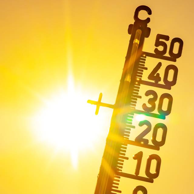 Heißes Wetter – Hitzewelle / Sommerhitze Hintergrund – Thermometer, gelb-oranger Himmel und Sonnenstrahlen