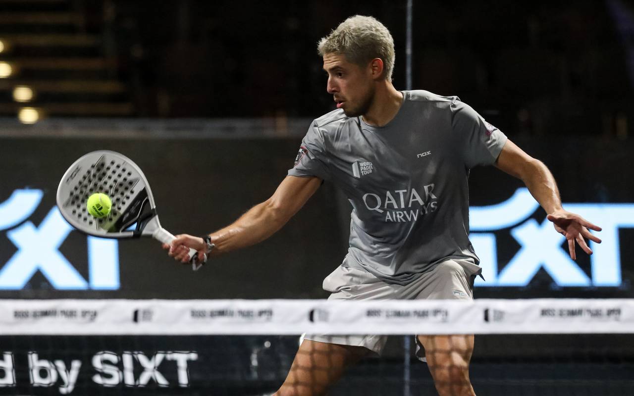Ein Padel-Spieler trifft den Ball mit seinem Schläger.