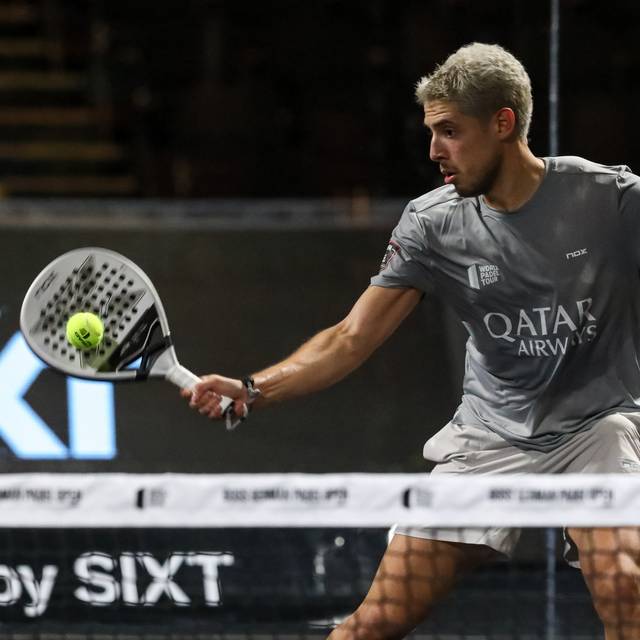 Ein Padel-Spieler trifft den Ball mit seinem Schläger.