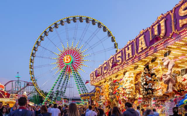 Die Düsseldorfer Rheinkirmes bei Nacht. Mit Riesenrad und dem Glückhaus, einer Losbude.