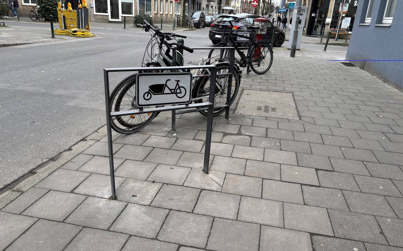 Ein Fahrradbügel auf der Luisenstraße. Im Hintergrund stehen zwei angeschlossene Fahrräder.