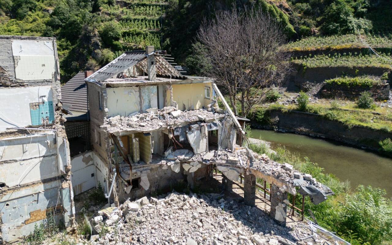 Die Ruinen von zwei bei der Flut im Sommer 2021 zerstörten Wohnhäusern stehen am Ufer der Ahr (Luftaufnahme mit einer Drohne). (Zu dpa „Ohnmacht und Rückzug - das Ahrtal drei Jahre nach der Flutkatastrophe“)