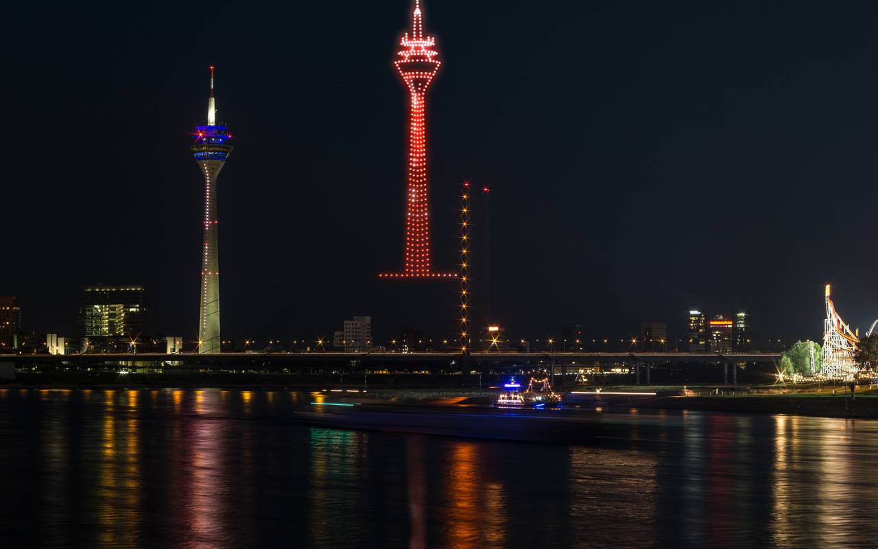 Eine Visualiesierung der Drohnenshow zur Rheinkirmes. Drohnen malen den Rheinturm in den Himmel.