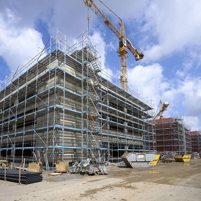 Auf der Baustelle ist das neue Luisengymnasium an der Völklinger Straße noch eingerüstet. Inmitten der Gebäude steht ein Baukran.
