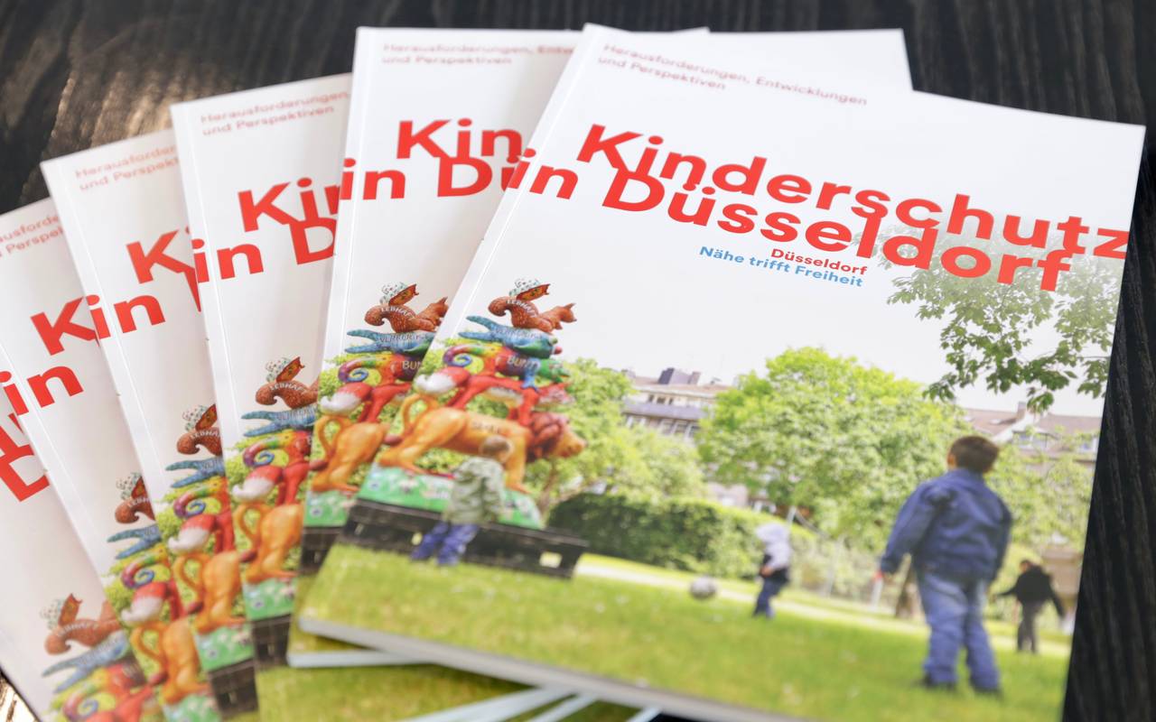 Die neue Broschüre "Kinderschutz in Düsseldorf" liegt auf einem Tisch.